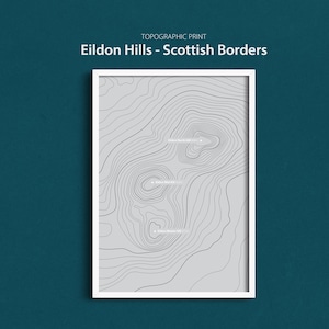May include: A framed topographic print of the Eildon Hills in the Scottish Borders. The print shows gray contour lines on a white background, with the text "Eildon Hills - Scottish Borders" at the top.