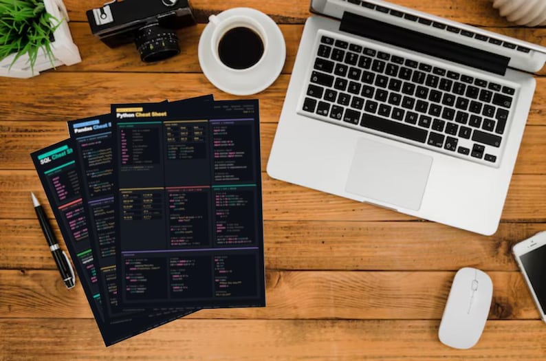 Pode incluir: Uma mesa de madeira com um laptop, uma x&iacute;cara de caf&eacute;, uma c&acirc;mera e v&aacute;rias folhas de dicas em preto e branco. As folhas de dicas t&ecirc;m texto colorido e s&atilde;o intituladas "SQL Cheat Sheet" e "Python Cheat Sheet". Um mouse branco e um smartphone tamb&eacute;m est&atilde;o na mesa.