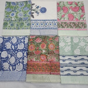 Puede incluir: Seis textiles rectangulares con estampados florales en azul, verde, rosa y naranja. Cada textil tiene un borde a rayas. Los diseños parecen ser estampados en bloque. Dispuestos uno al lado del otro.