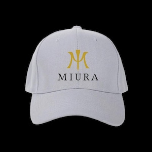 May include: A light gray baseball cap with a curved brim. The cap features a gold emblem and the word "MIURA" in black, centered on the front. The background is solid black.