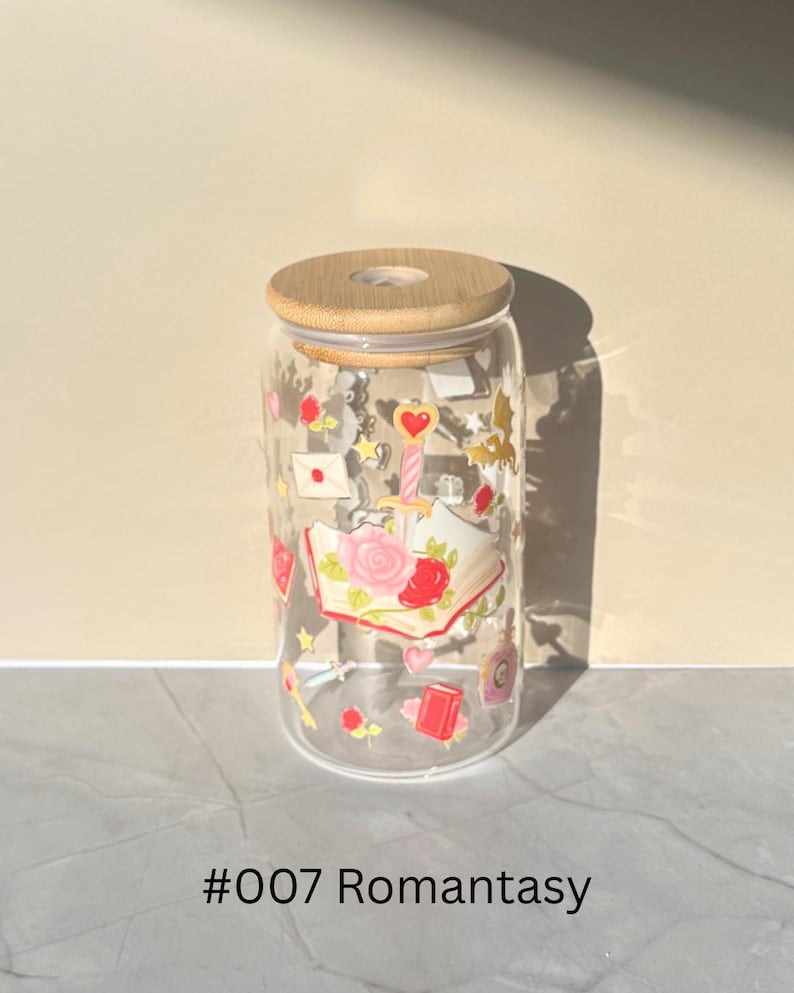 May include: Clear glass can-shaped tumbler with a bamboo lid. The glass is decorated with romantic-themed illustrations, including roses, hearts, and books. The text "#007 Romantasy" is printed at the bottom.