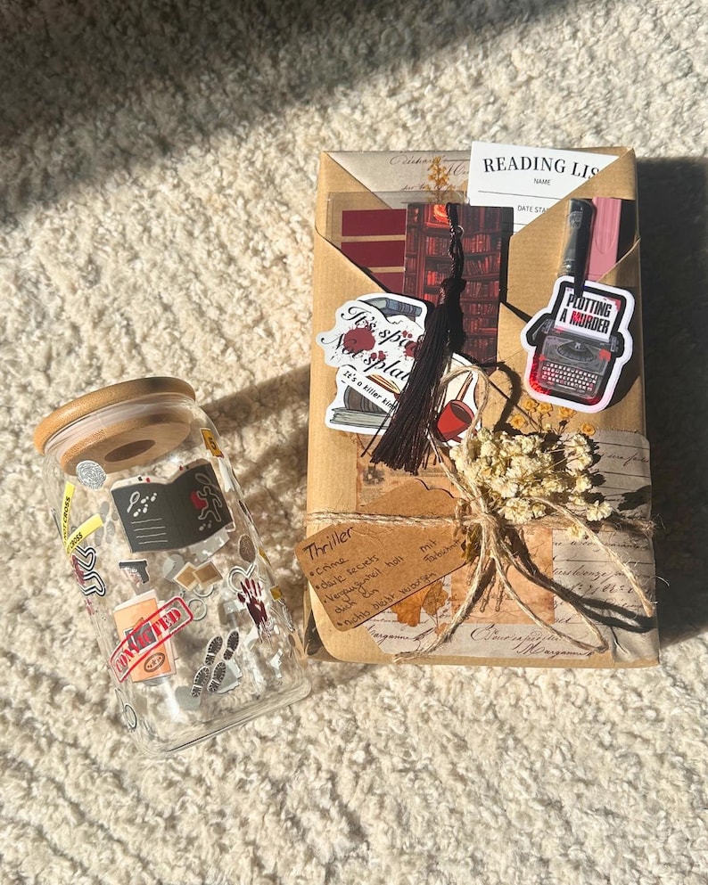 May include: A clear glass jar with a wooden lid and a wrapped package. The jar is covered in stickers with crime-themed graphics. The package is wrapped in brown paper and tied with twine, featuring stickers and a tassel. Text on the package reads "Plotting a Murder."