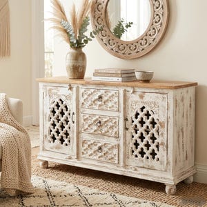 Puede incluir: Un letrero de madera hecho a mano con el texto "Welcome to our home" en un estilo manuscrito. El letrero está pintado de blanco con un acabado envejecido y un diseño floral decorativo.