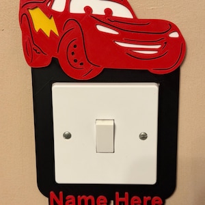 Könnte beinhalten: Weißer Keramikbecher mit schwarzem Henkel und dem Text "But First, Coffee" in schwarzer Schrift. Der Becher steht vor einem verschwommenen Hintergrund, der eine gemütliche Umgebung andeutet.