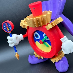 May include: A whimsical, 3D-printed clock character with a red body, gold accents, and purple shoes. The clock face has blue and yellow details with a green hand. It holds a matching scepter with a clock face.