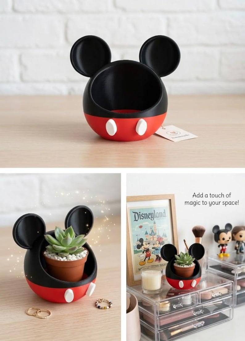 May include: A spherical black and red container shaped like a mouse head with two large round ears and two white oval buttons on the front. The container has an open top and is designed to hold small items or a small potted succulent plant.