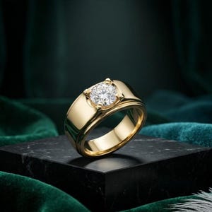 May include: A gold ring featuring a wide, polished band and a single, round, brilliant-cut clear gemstone set in a four-prong mounting. The metal has a reflective, smooth surface, and the stone is positioned centrally on the top of the band.