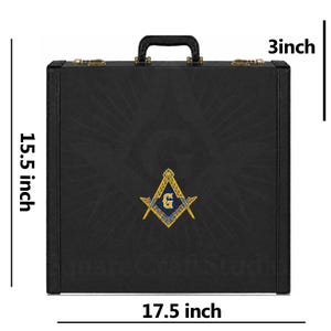 May include: A black rectangular carrying case with a top handle and gold-tone metal latches. The front features a centred blue and gold Masonic square and compass emblem with the letter G. Dimensions are 17.5 inches wide, 15.5 inches high, and 3 inches deep.