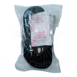 May include: A black strap with a metal hook and buckle, packaged in a clear plastic bag. A small packet labeled "SILICA GEL DESICCANT DO NOT EAT" is included. The product is likely for securing or fastening.