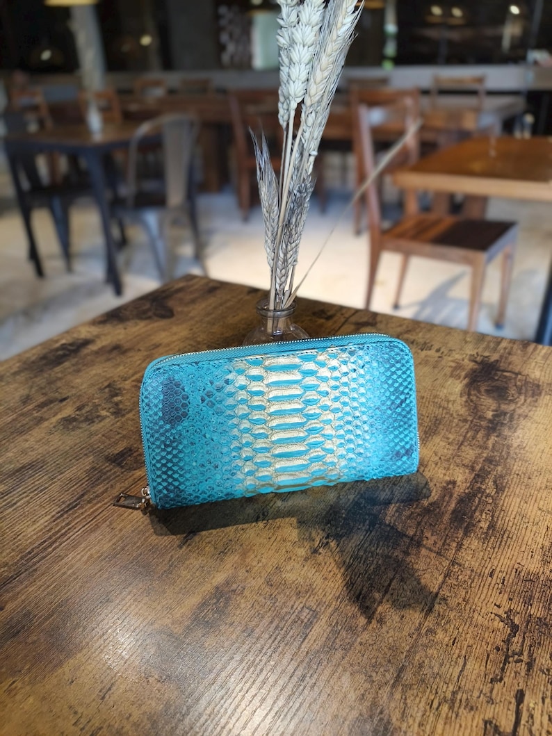 Op de afbeelding: Een witte keramische mok met een zwart handvat en de tekst "But First, Coffee" in een zwarte, vette letter. De mok staat op een wit oppervlak.