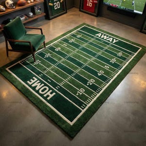May include: A rectangular green and white football field rug. The rug features yard lines, end zones with "HOME" and "AWAY" in white block letters. The rug is a decorative item for a sports-themed room.