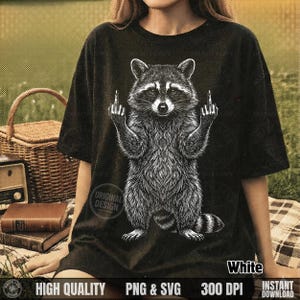 Woman sitting on a picnic blanket wearing a black t-shirt with a white vintage halftone edgy trash panda design