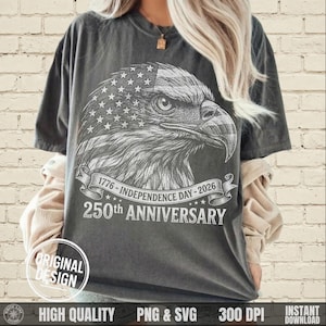 May include: Dark gray t-shirt featuring a detailed illustration of an eagle's head with an American flag design. The shirt includes text that reads "1776 - Independence Day - 2026" and "250th Anniversary". The design is labeled "Original Design".