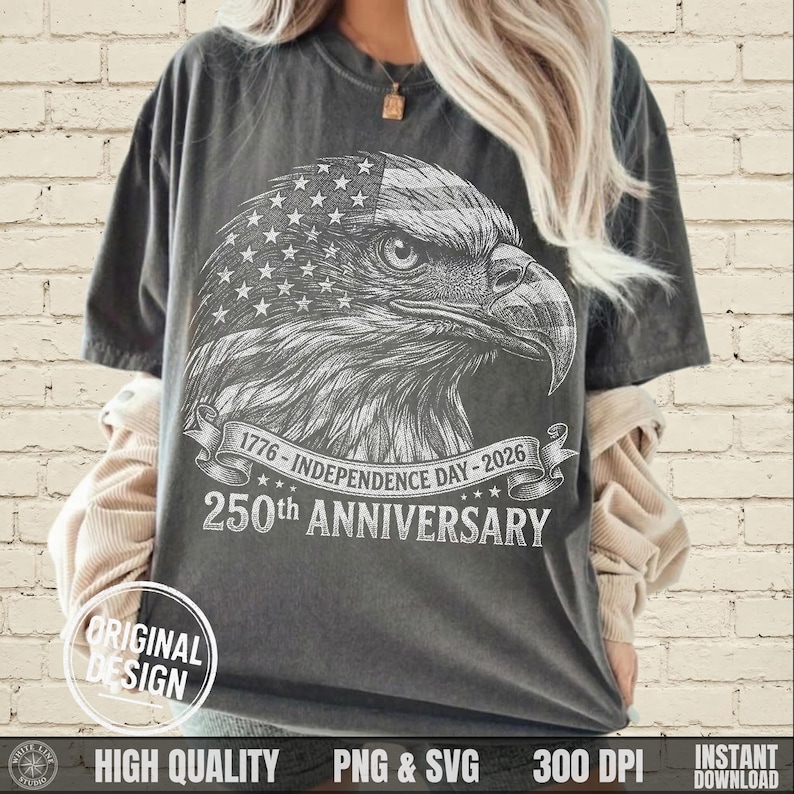 May include: Dark gray t-shirt featuring a detailed illustration of an eagle's head with an American flag design. The shirt includes text that reads "1776 - Independence Day - 2026" and "250th Anniversary". The design is labeled "Original Design".