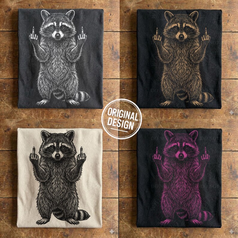 Four folded t-shirts in dark grey, black, cream, and black showing white, beige, black, and pink variations of the edgy raccoon design