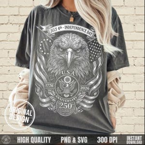 May include: Dark gray t-shirt featuring a detailed graphic of an eagle, American flags, and the text "JULY 4th - INDEPENDENCE DAY". The design includes the text "U.S.A.", "1776", "2026", and "250 YEARS OF FREEDOM".