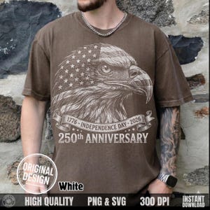 May include: Brown t-shirt featuring a detailed illustration of an eagle with an American flag design. The shirt commemorates the 250th anniversary of Independence Day, with text reading "1776-INDEPENDENCE DAY-2026" and "250th ANNIVERSARY". The design includes the words "ORIGINAL DESIGN" and "White".
