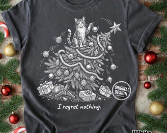 Może przedstawiać: Ciemnoszary t-shirt z białą grafiką liniową przedstawiającą kota siedzącego na szczycie udekorowanej choinki, otoczonego bombkami i prezentami. Poniżej ilustracji znajduje się napis "I regret nothing.".