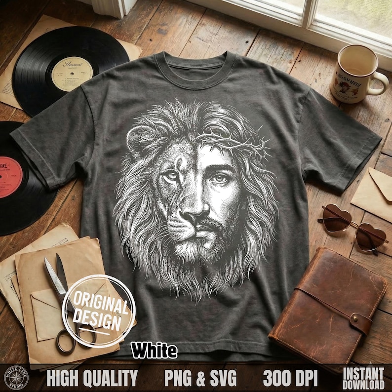 May include: Dark gray t-shirt featuring a detailed white graphic of a lion's face merged with Jesus' face, wearing a crown of thorns. The shirt has short sleeves and a crew neck. The words "White" and "Original Design" are also visible.