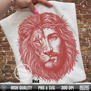 Hand holding a white t-shirt with the red hand-drawn Jesus is King lion face graphic