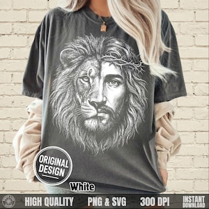 May include: Dark gray t-shirt featuring a split design: one half a lion's face, the other half a depiction of Jesus wearing a crown of thorns. The shirt includes the text "ORIGINAL DESIGN" in a white circle, and "White" below the design.
