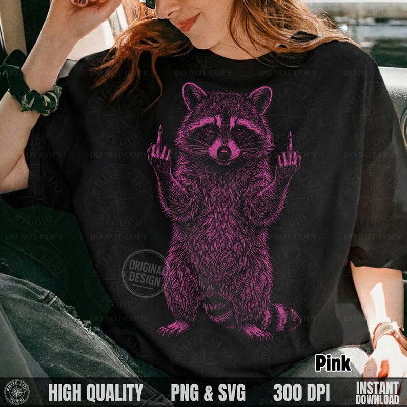 Woman sitting in a car wearing a black t-shirt featuring a pink vintage halftone sassy raccoon design