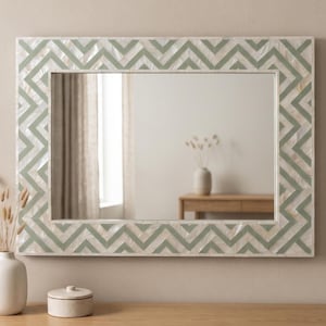 May include: A rectangular wall mirror featuring a wide frame decorated with an inlaid chevron pattern. The frame consists of alternating segments of iridescent white mother-of-pearl and matte sage green material, creating a geometric zigzag design.