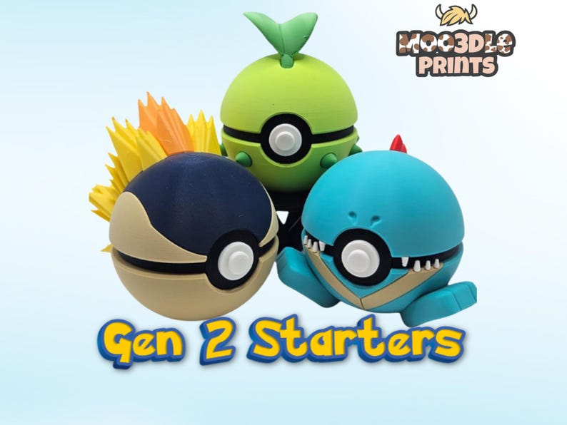 May include: Three colourful, stylised figures resembling Pok&eacute;mon characters. One is green with a leaf, another is blue, and the third is navy and tan. The text "Gen 2 Starters" is displayed below the figures. The logo "MOOD3D PRINTS" is in the upper right.