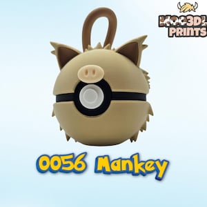 May include: A tan and brown 3D-printed keychain featuring a cartoon character with a pig-like nose and ears. The keychain has a black band around the middle and a loop at the top. The text "0056 Mankey" is displayed below.