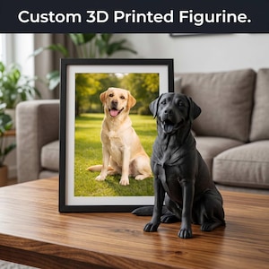 May include: A black 3D-printed Labrador figurine sits on a wooden table next to a framed photo of a yellow Labrador. The photo is in a black frame. The text "Custom 3D Printed Figurine" is at the top of the image.