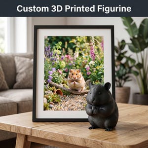 Pode incluir: Uma estatueta de hamster preta impressa em 3D ao lado de uma fotografia emoldurada de um hamster em um jardim. A fotografia está em uma moldura preta. O texto "Custom 3D Printed Figurine" está no topo da imagem.