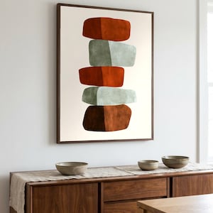 Può includere: Una stampa artistica incorniciata che presenta una pila verticale di cinque forme astratte e arrotondate in tonalità alternate di arancione bruciato, verde salvia e marrone scuro, su uno sfondo bianco sporco all'interno di una cornice in legno.
