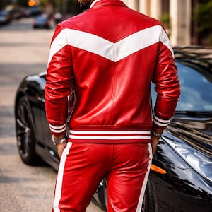 May include: Red leather jacket and pants set with white accents. The jacket features a white chevron design across the shoulders and white stripes on the sleeves. The pants have a white stripe down the side. The outfit is worn with a silver watch.