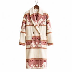 May include: A long, double-breasted coat in an off-white color featuring a geometric pattern in shades of dusty rose, burgundy, and tan. The coat has a wide shawl collar, long sleeves, and two large patch pockets on the front with four buttons.