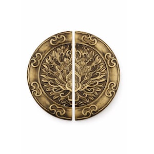 May include: Two-piece antique brass door pulls. Each piece is a half-circle with an ornate floral design in the center and a decorative border. The pulls are a warm, golden color, and the design is raised.