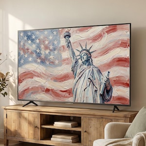 Könnte beinhalten: Ein großer Flachbildfernseher zeigt ein Gemälde der Freiheitsstatue vor dem Hintergrund der amerikanischen Flagge. Der Fernseher steht auf einer rustikalen Medienkonsole aus Holz in einem Wohnzimmer mit neutralen Möbeln.