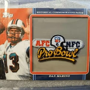 May include: A Topps 2009 Postseason Patches trading card featuring Dan Marino in a white jersey with the number 13. The card includes an embedded Pro Bowl patch with AFC and NFC text, a football helmet icon, and the word Pro Bowl in yellow script.