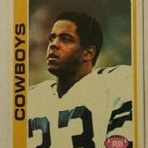Puede incluir: Una tarjeta de colección de fútbol vintage con Tony Dorsett de los Dallas Cowboys. La tarjeta tiene un borde amarillo con la palabra "COWBOYS" verticalmente a la izquierda. Dorsett lleva una camiseta blanca con el número 33 en negro.
