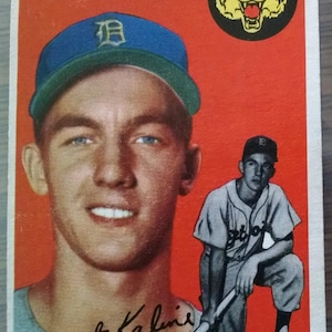 May include: Vintage baseball card featuring Al Kaline, outfielder for the Detroit Tigers. The card has a red background with a portrait of Kaline in a blue cap and a smaller image of him in a baseball uniform. The Detroit Tigers logo is also visible.