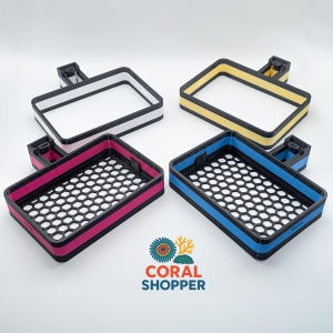 May include: Four rectangular soap dishes with black frames and colored inserts in white, yellow, pink, and blue. Each dish features a honeycomb-patterned base and a small mounting bracket on the back. The logo CORAL SHOPPER is printed below.