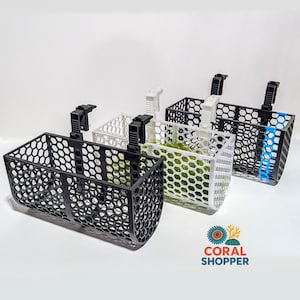 May include: Three rectangular aquarium baskets with a honeycomb pattern, each featuring a black or white adjustable mounting clip. The baskets are black, white, and black with a blue accent, containing green moss. The logo CORAL SHOPPER is visible.