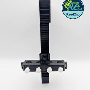 May include: Black 3D-printed aquarium accessory with a vertical, ridged support and a horizontal section holding four white, cylindrical fasteners. The ReefZip logo is in the upper right corner, featuring a tree and the brand name.