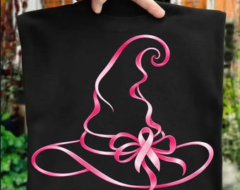 May include: A black t-shirt featuring a graphic design of a witch hat outlined in a vibrant pink ribbon. The ribbon forms the shape of the hat and includes a decorative bow at the base, with the overall design rendered in a continuous flowing line.