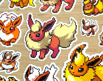 May include: A collection of die-cut stickers featuring pixel art of the orange and yellow fire-type creature Flareon in various poses, including standing, sitting, and running, with white borders around each individual character design.