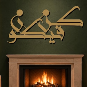 May include: A gold-colored metal wall art piece featuring stylized Arabic calligraphy. The design consists of interconnected geometric shapes and flowing lines that form characters, mounted on a dark green wall above a fireplace.