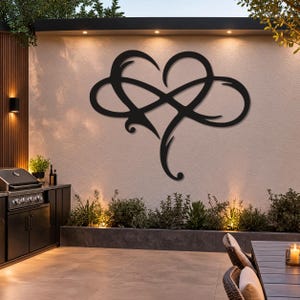 May include: A black metal wall art piece featuring a stylised heart shape intertwined with an infinity symbol. The design consists of smooth, curved lines forming a continuous loop that merges the two distinct shapes into one cohesive silhouette.