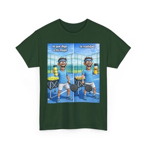 Puede incluir: Camiseta verde oscuro con una ilustración de dibujos animados humorística. La imagen muestra a un hombre en una cancha de pádel con el texto "lo que digo a mi mujer" y "la realidad". El hombre sostiene pelotas de tenis y una bebida.