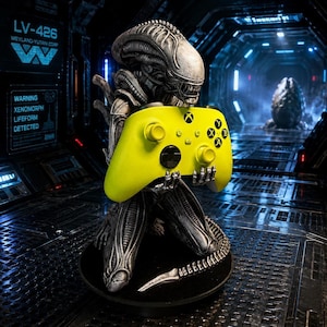 May include: A silver and black Xenomorph figurine kneeling on a circular base, holding a bright yellow Xbox wireless controller. The creature features a detailed biomechanical exoskeleton with a long tail and is positioned in a dark corridor.