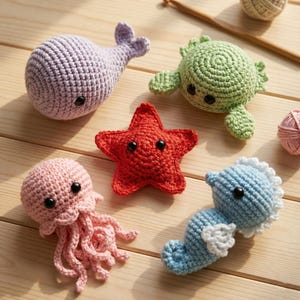 Puede incluir: Una colección de criaturas marinas hechas a mano con ganchillo: una ballena lavanda, una tortuga verde, una estrella de mar roja, una medusa rosa y un caballito de mar azul. Cada criatura tiene ojos de seguridad negros y está hecha de hilo suave.