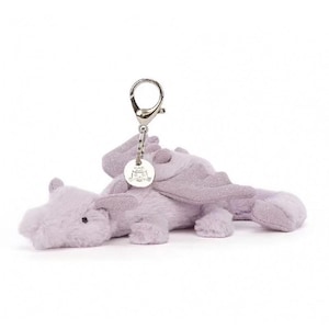May include: A soft, lavender dragon keychain with silver-tone metal hardware. The dragon features textured fur, wings, and a small, round tag with an embossed design. The dragon is lying down on a white background.